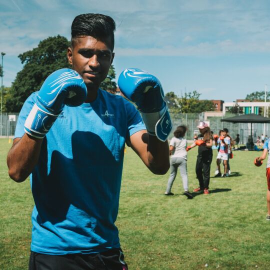 Leiding toont bokshandschoenen tijdens sportworkshop